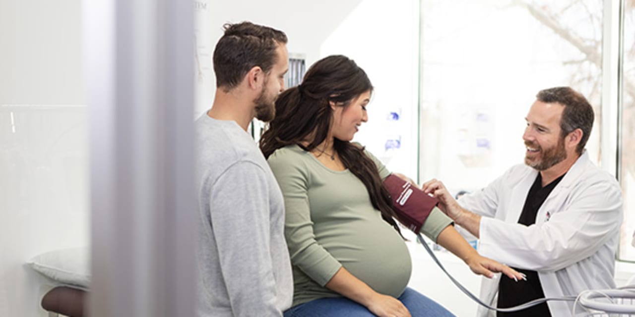 woman with high-risk pregnancy has her blood pressure checked by a high risk obgyn or maternal fetal medicine doctor