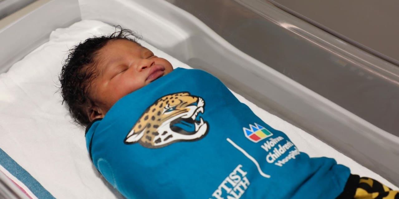 Baby wearing a sleep sack sleeping in a crib