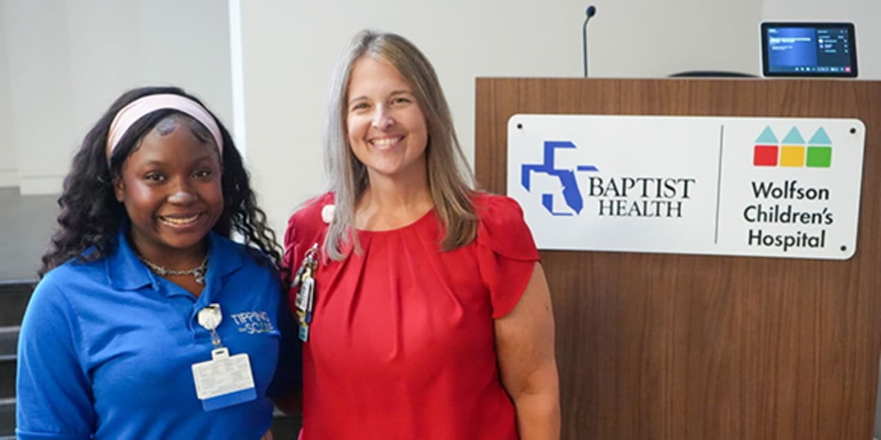 smiling mentor and mentee stand in front of a lectern