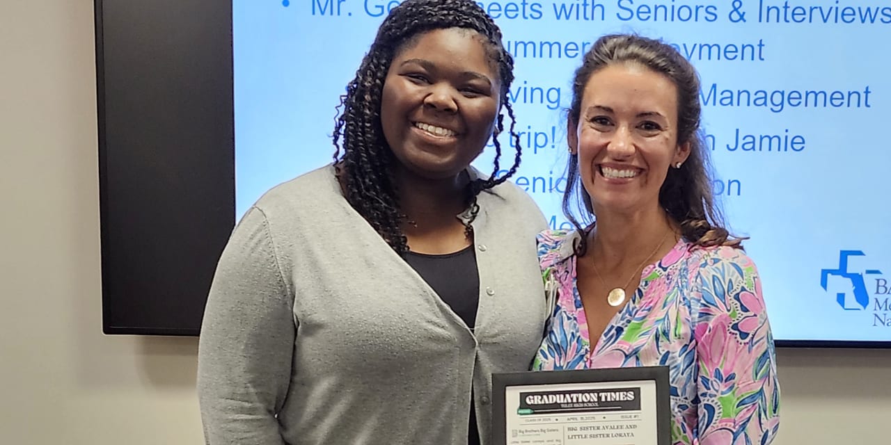 two smiling women standing together holding an award