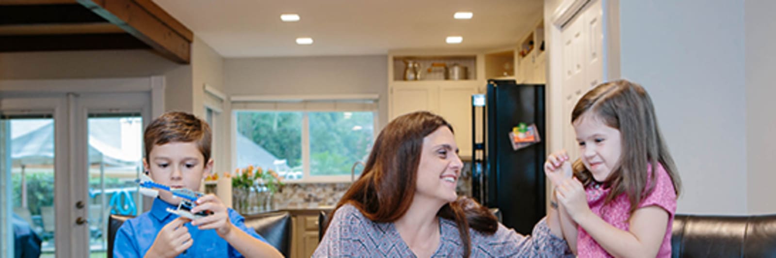 mom plays with two young children assembling a puzzle