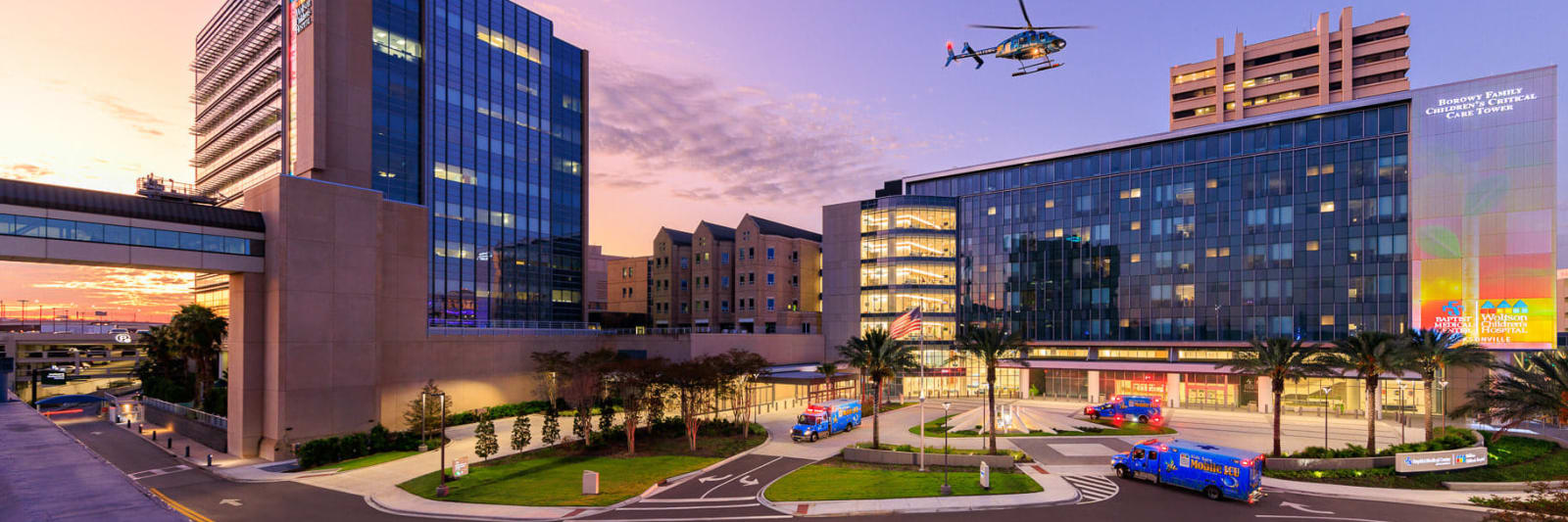exterior of Wolfson Children's hospital and Borowy Family Critical Care Tower in the evening with Kids Kare helicopter flying over