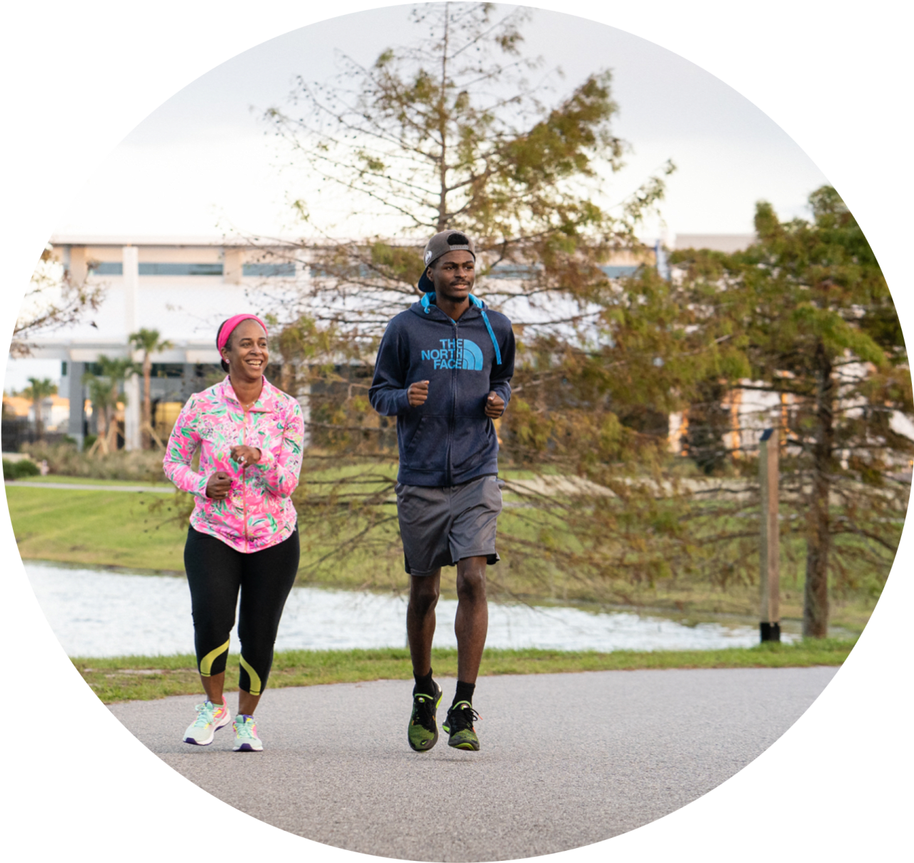 a man and woman jogging on the path at Baptist Clay Medical Campus.