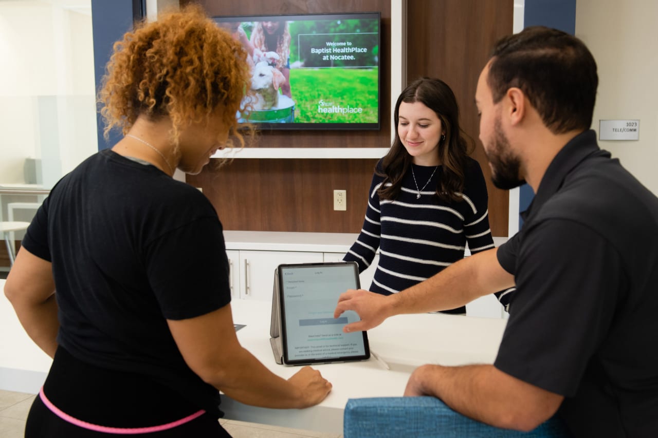 group of wellness coaches meeting registering a woman at the front desk