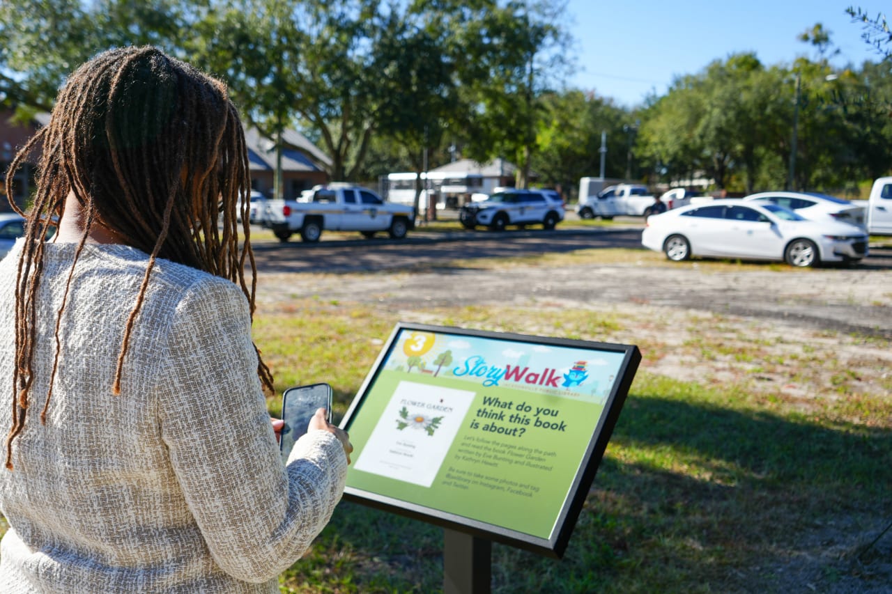 woman looking at a storywalk sign