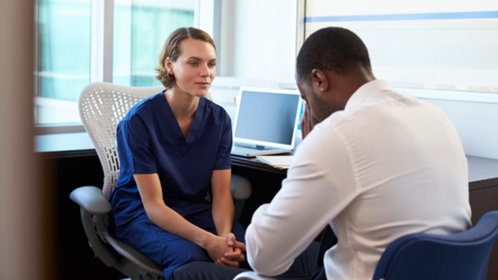 A nurse converses with a patient struggling with mental health.