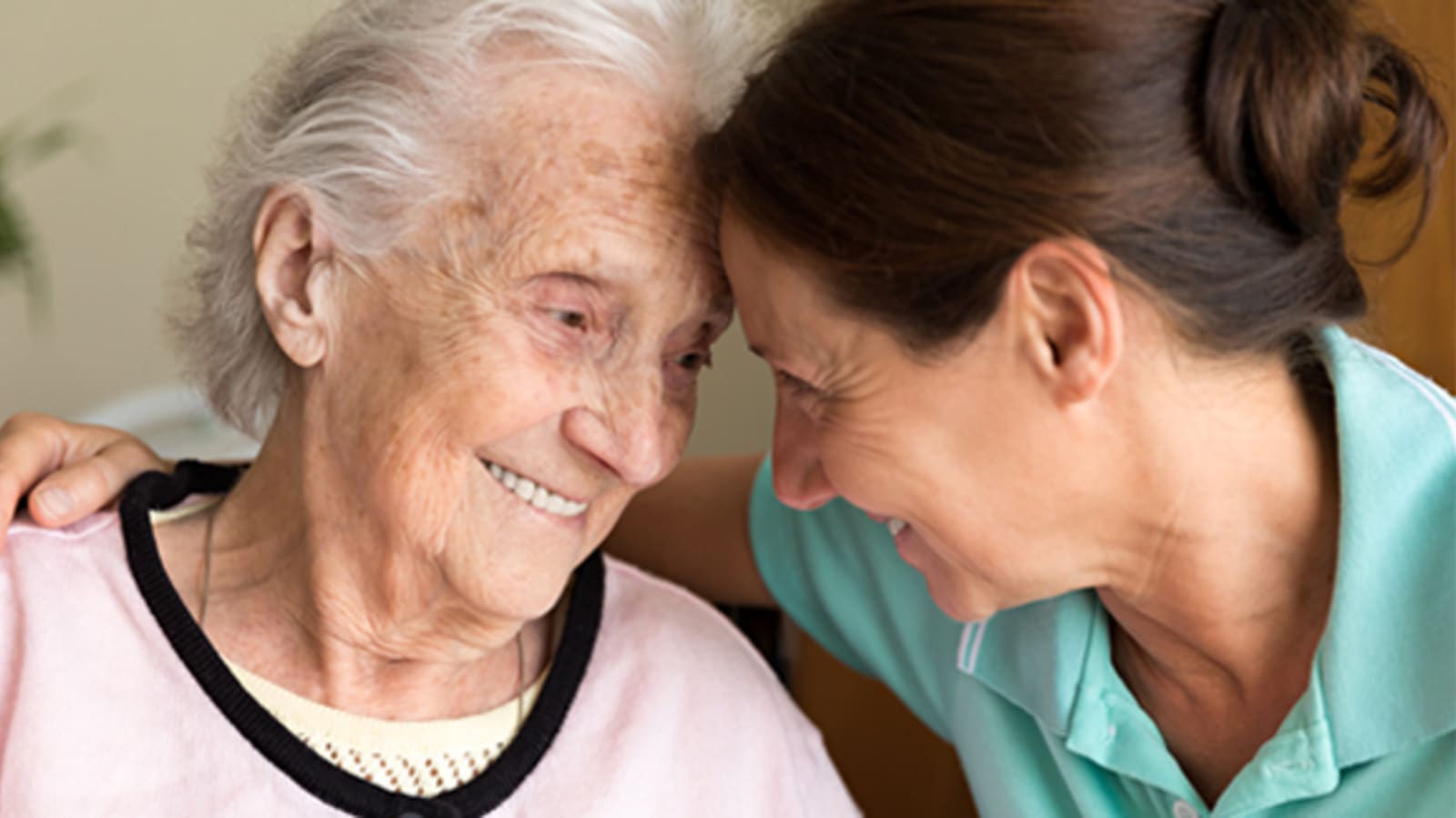 an elderly woman being embraced by a younger woman
