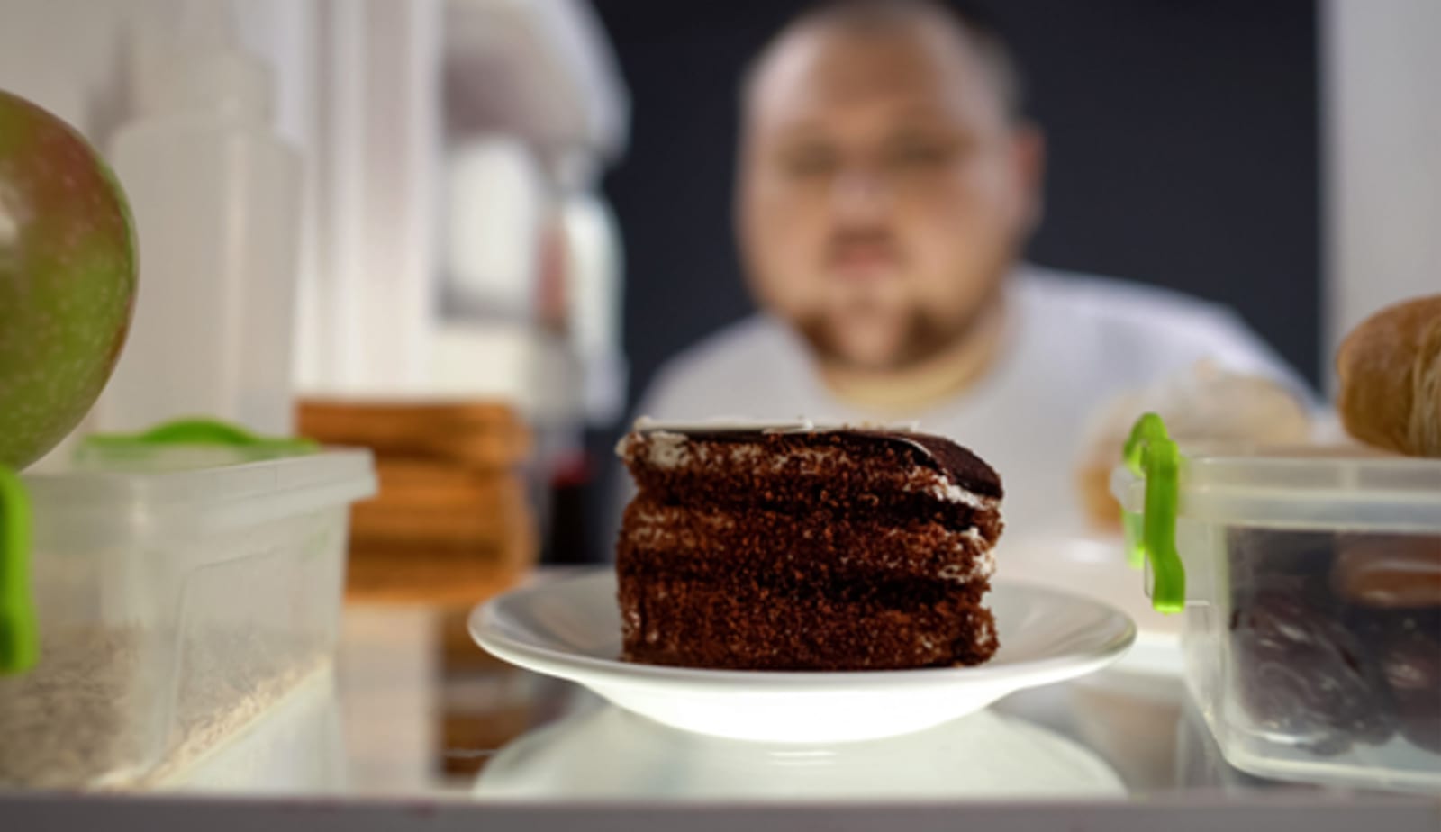 Man looking at chocolate cake in refrigerator