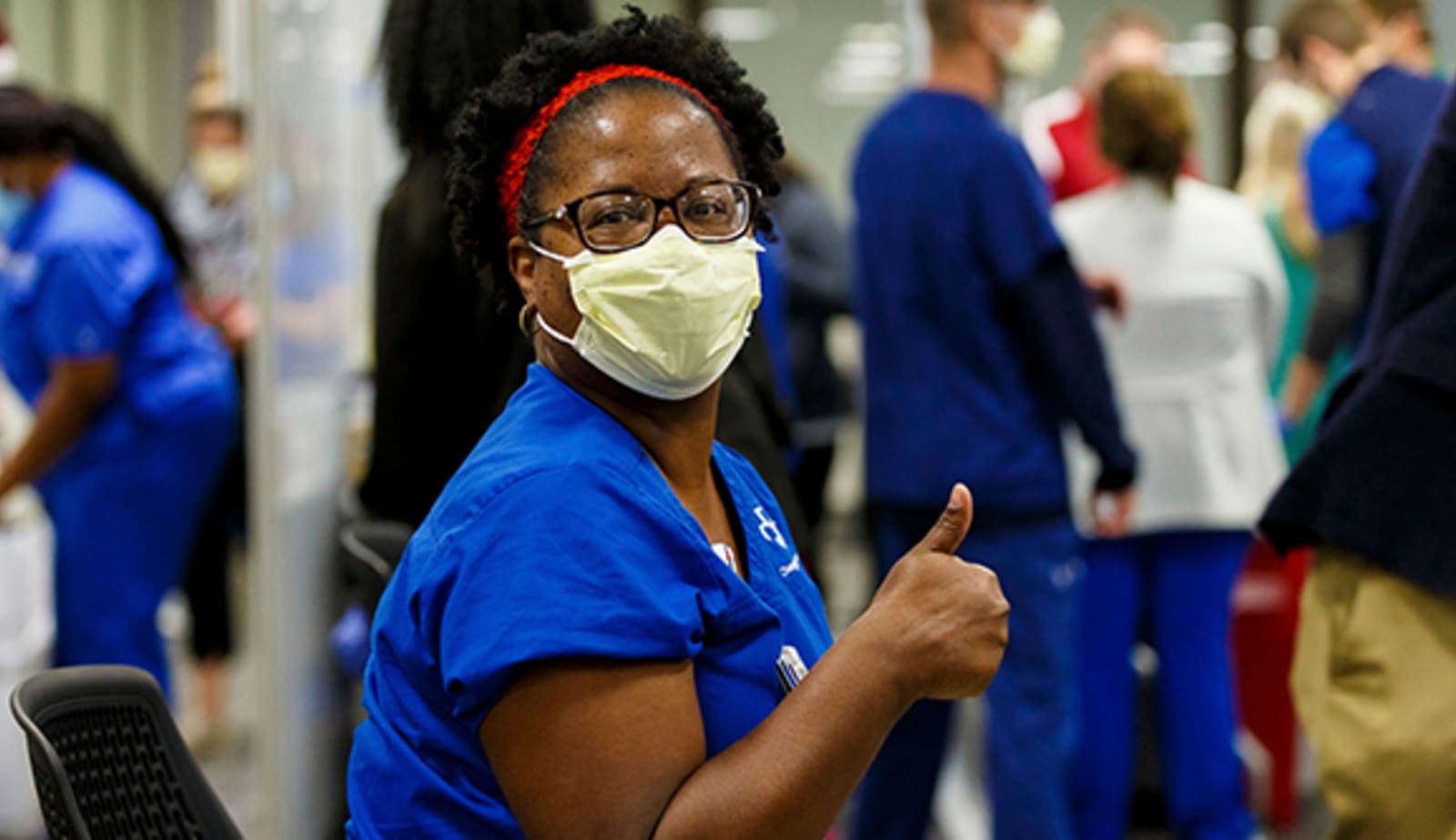 Baptist healthcare professional getting COVID-19 vaccine with a thumbs up