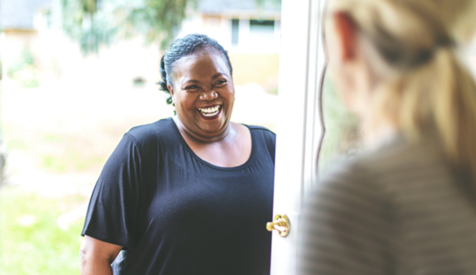 Woman is greeted at a friend's front door