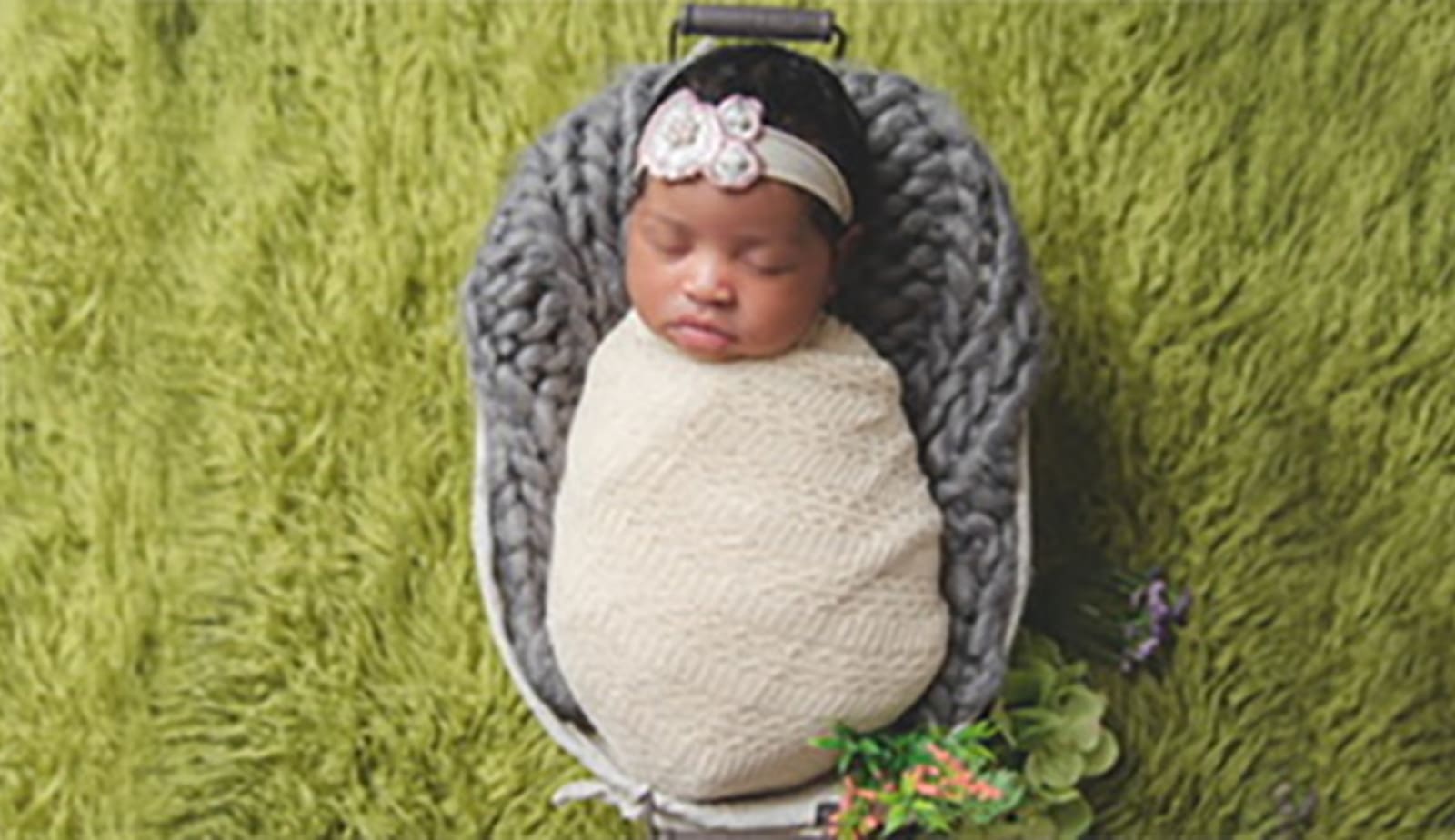 Little infant lying in bassinette. 