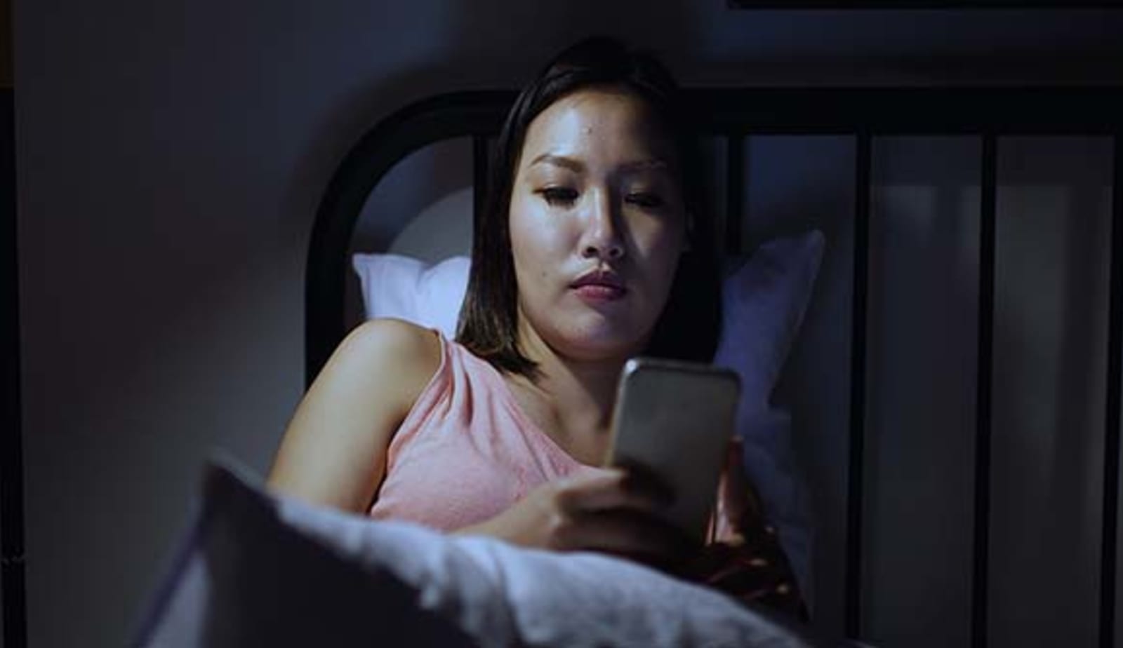 woman looking at her phone screen in the dark