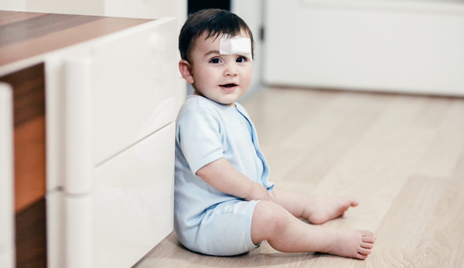a baby with a bandage on his head from a bump