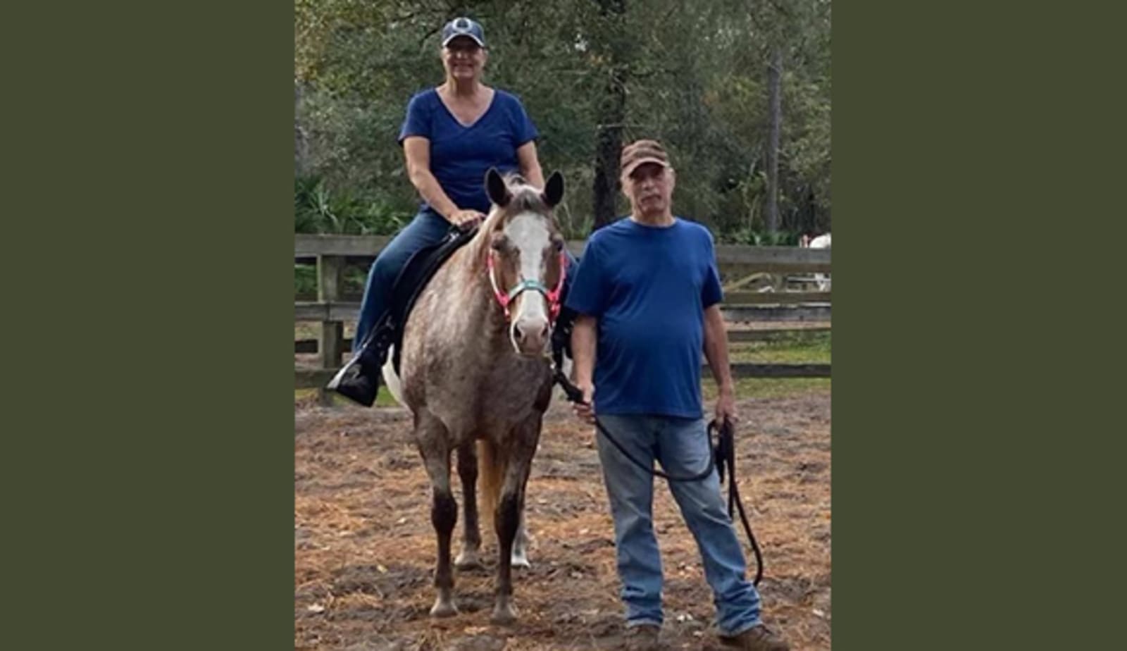 A women on a horse with a man standing beside the horse and the woman.