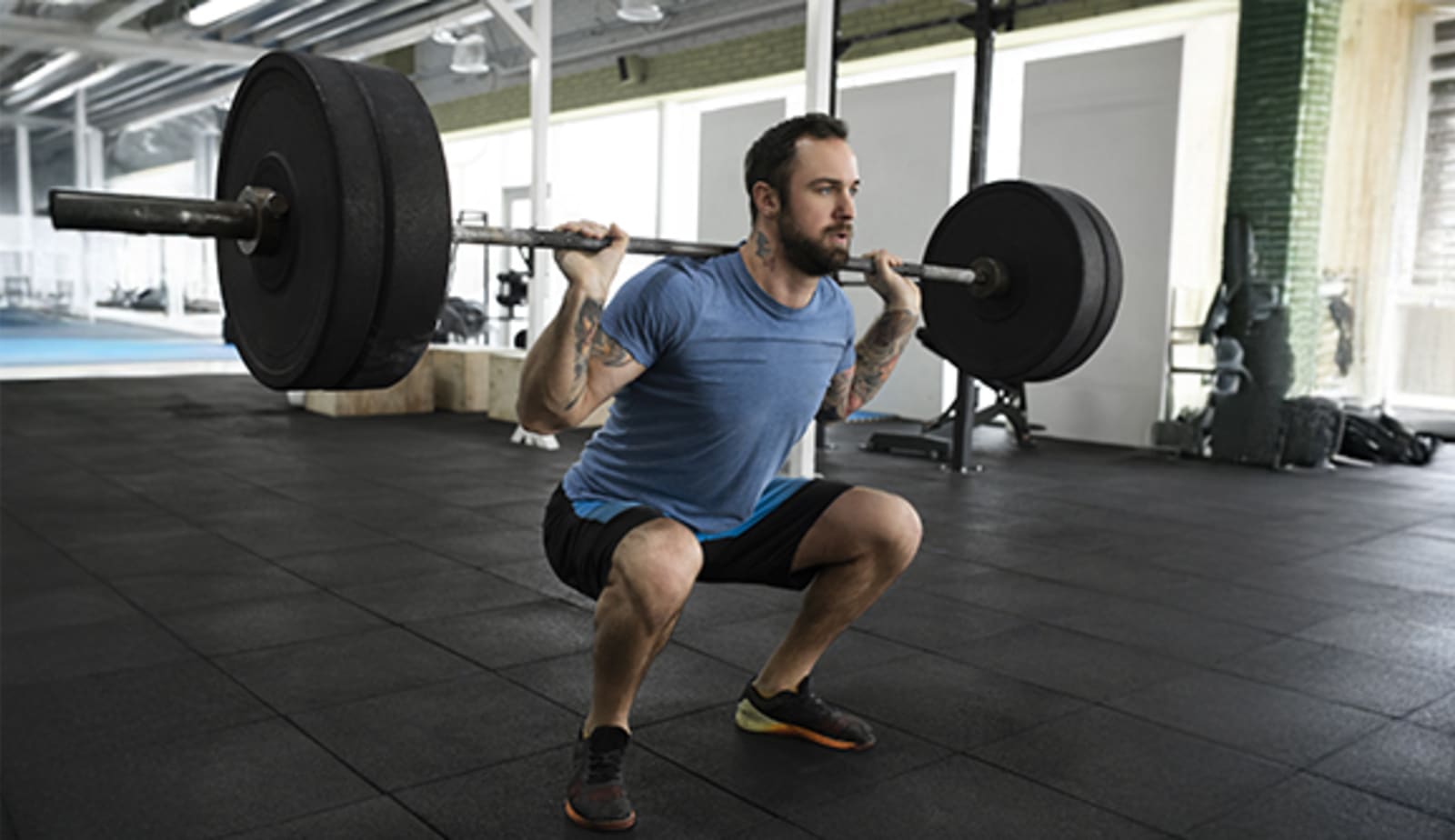A man uses proper lifting techniques to avoid injury