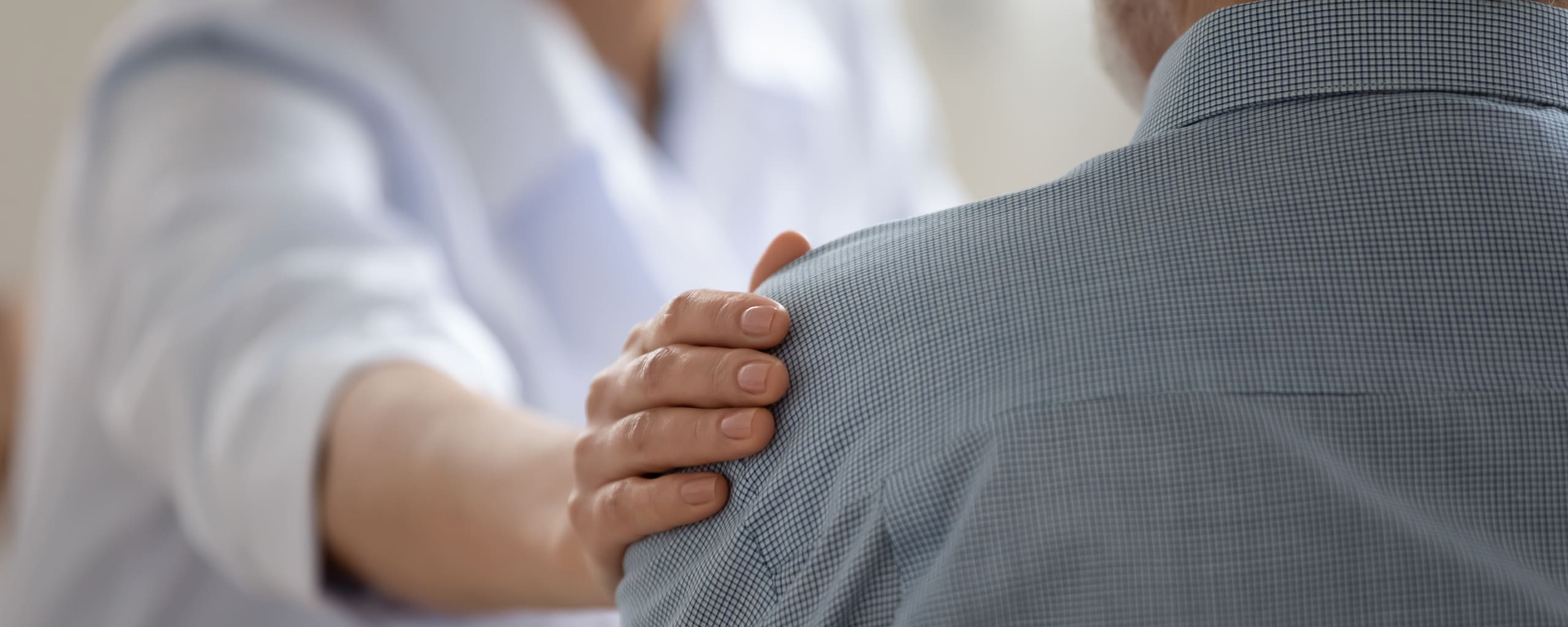 close up of doctor touching a patient's shoulder