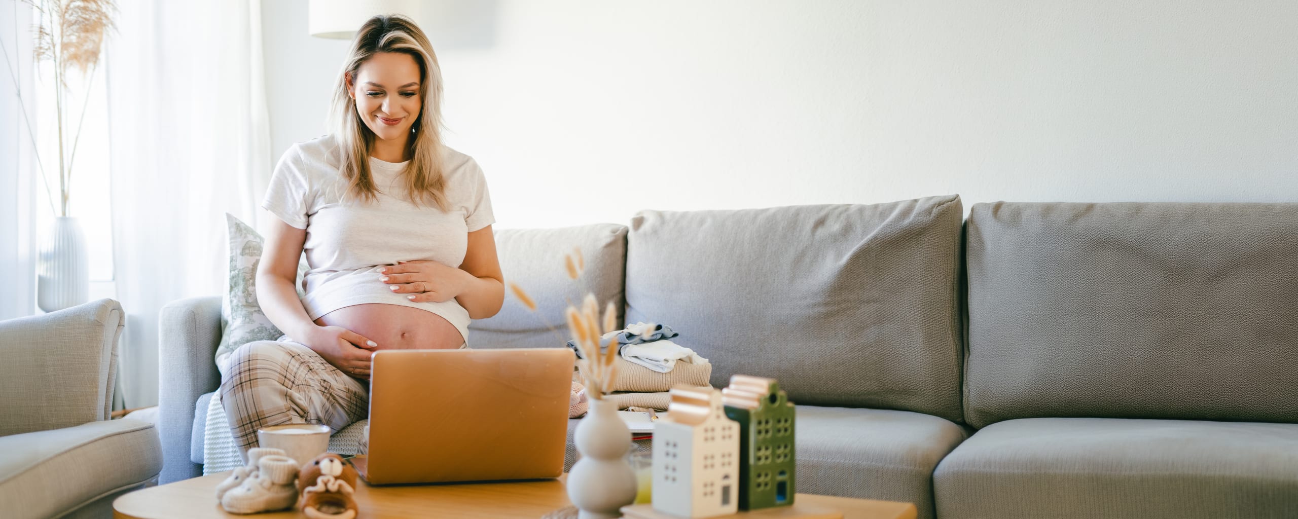 pregnant woman sitting on a couch in her brightly lit home