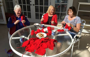 women crocheting outside together