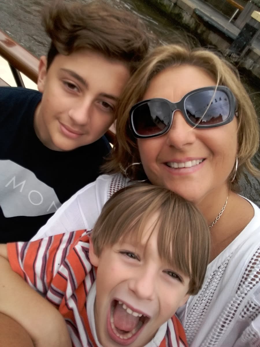 smiling mom posing with her 2 sons