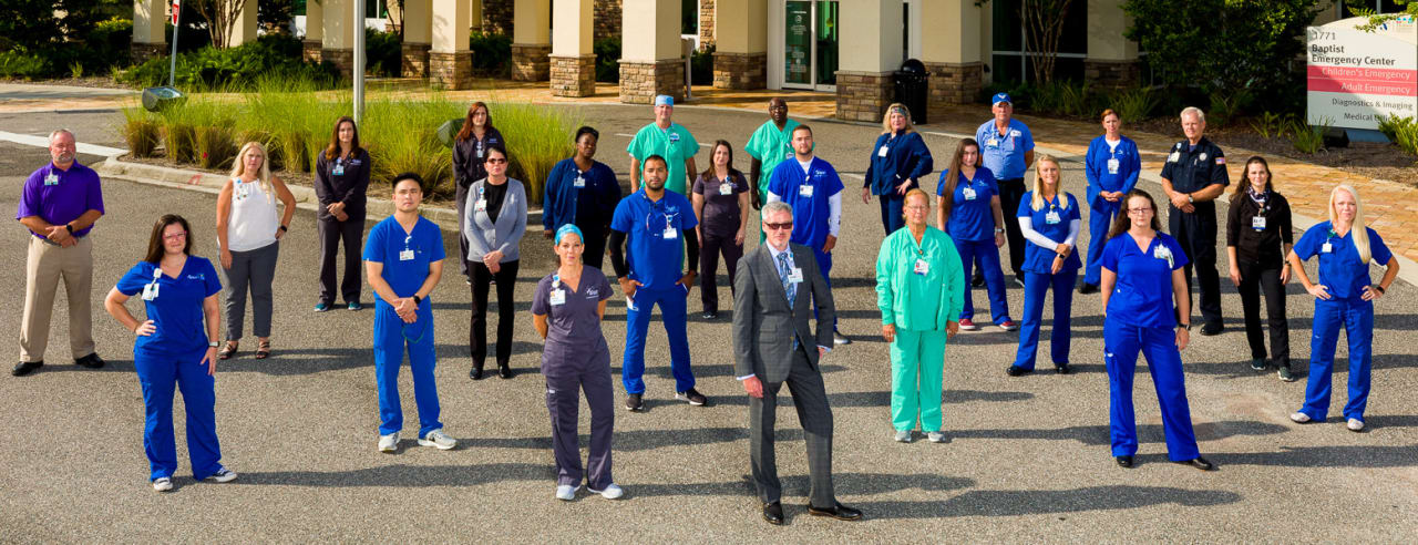 a large group of baptist health employees standing outside a medical facility